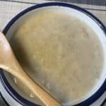 best bowl of Scottish porridge served in white bowl, cream mat background.