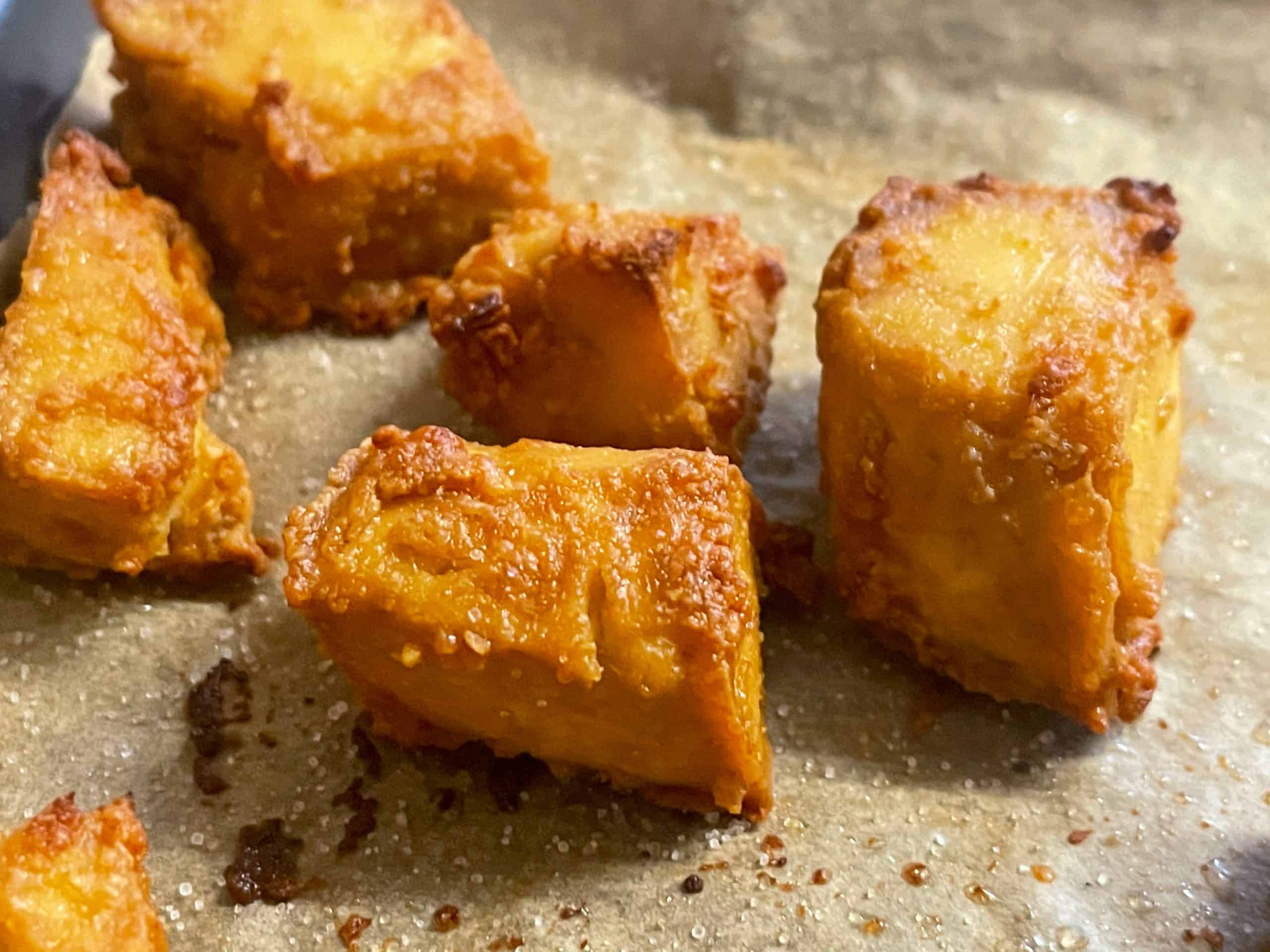 close up of crispy tofu bites on baking tray.