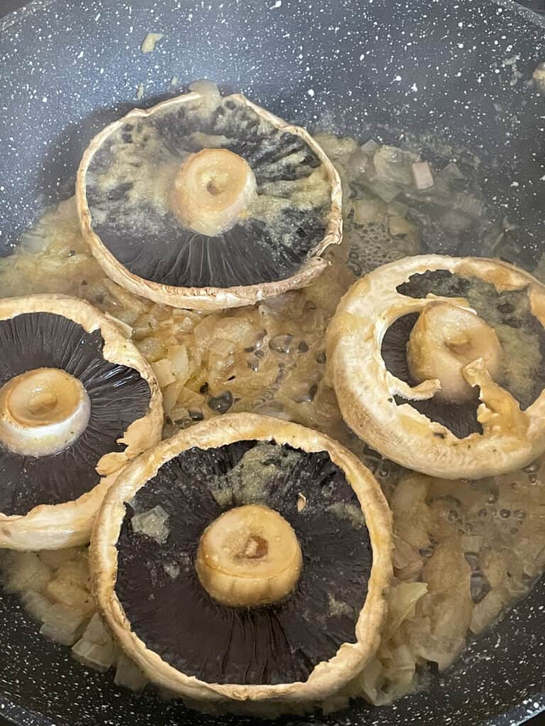 Mushrooms flipped over in pan.