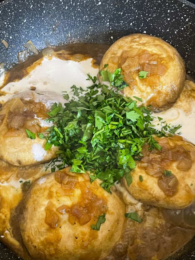 Chopped parsley and cream added to mushrooms.