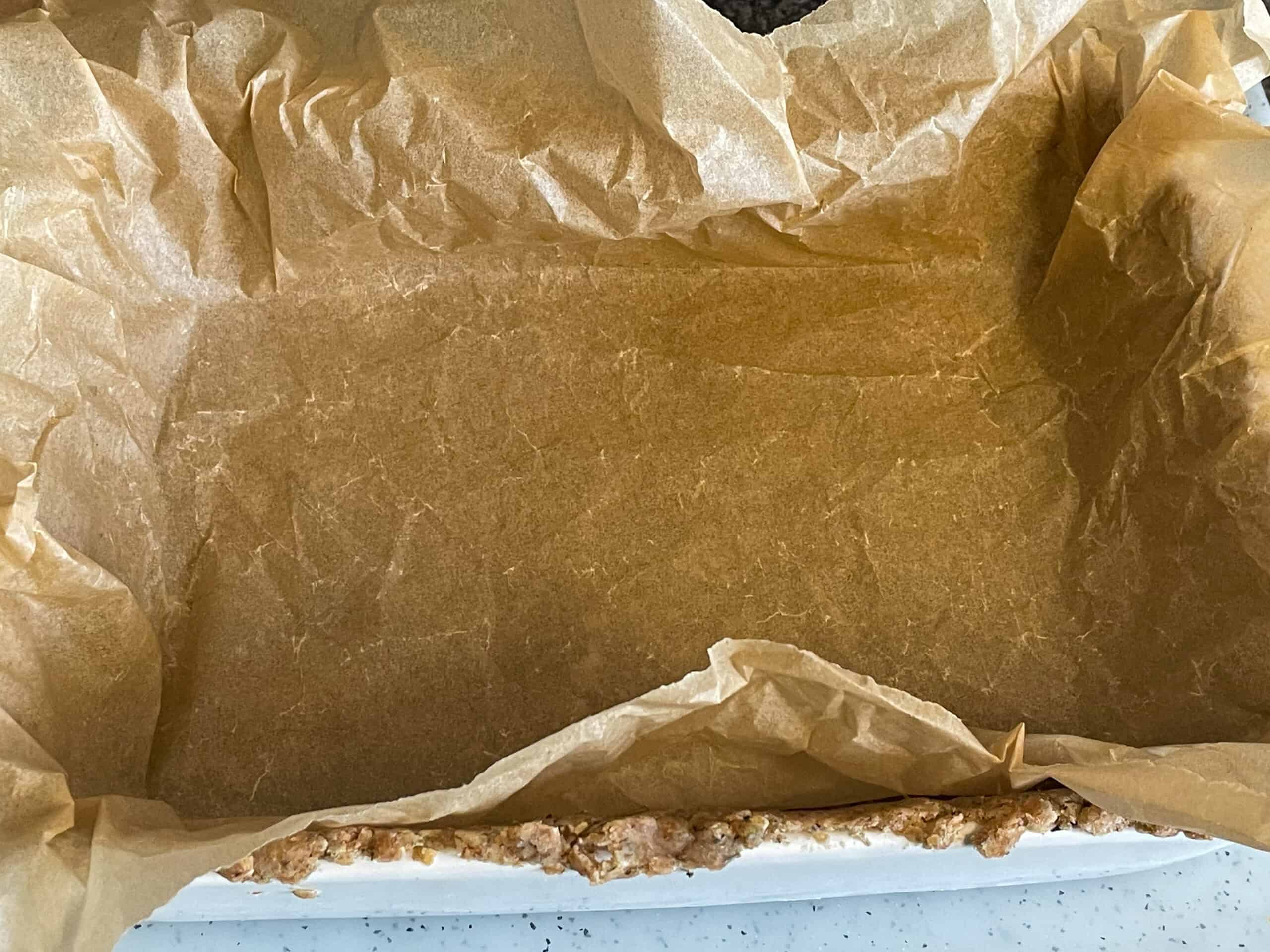 Greaseproof paper added to uncooked pastry in baking dish.