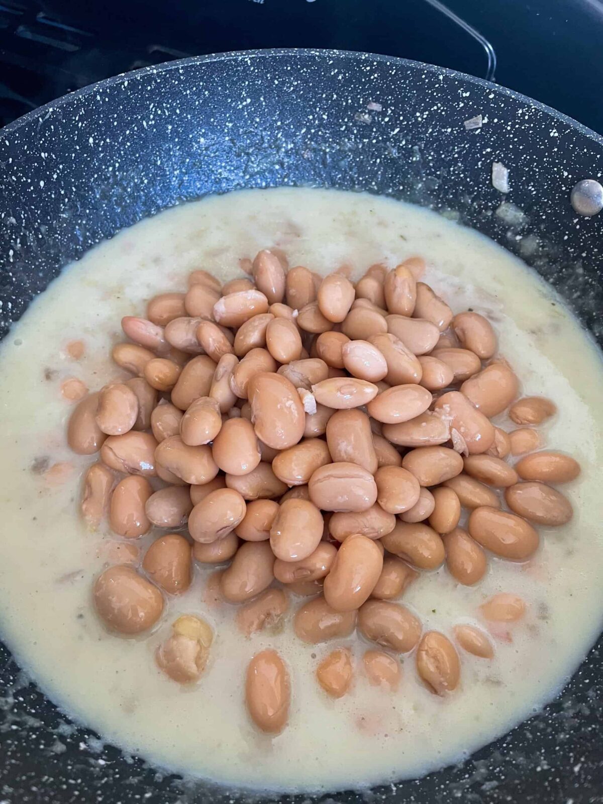 Butterbeans added to the sauce in the pan.