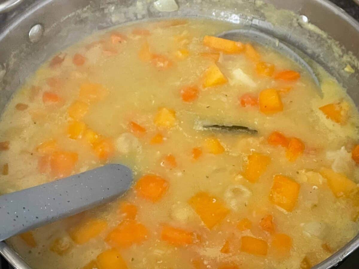 Lentil soup in the pan, grey soup ladle in the pan.