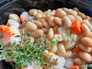 root veggies, garlic, butterbeans and fresh herbs in the saucepan.