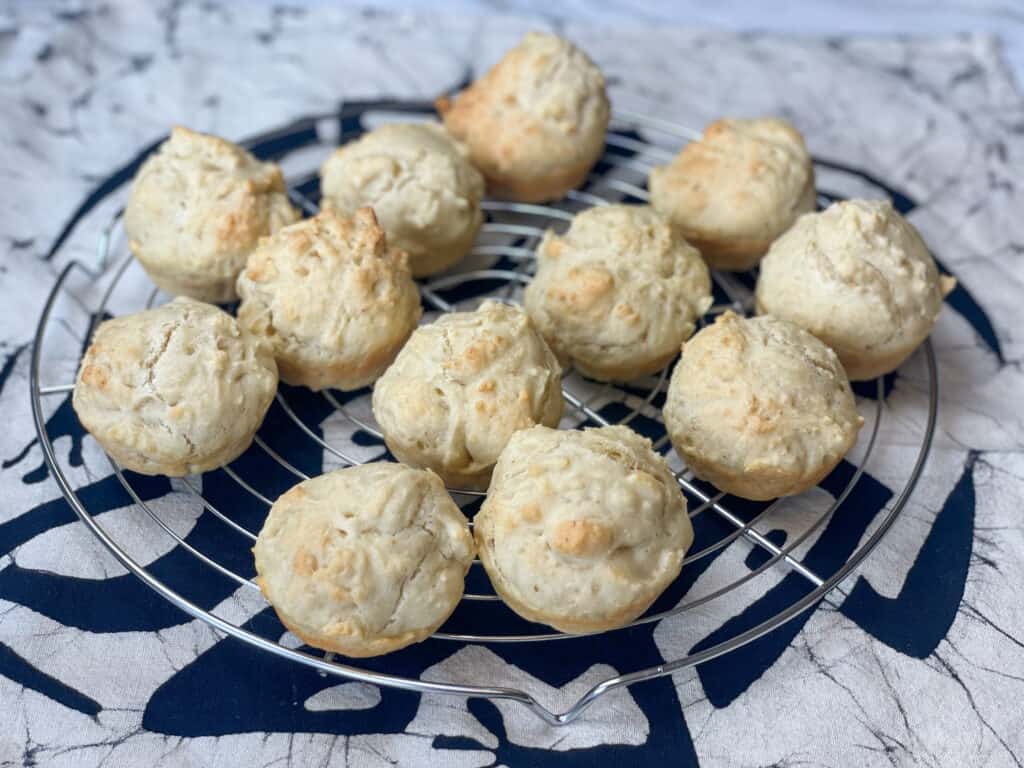 vegan quick dinner rolls cooling on circular wire rack with cream mat underneath with an animal pattern