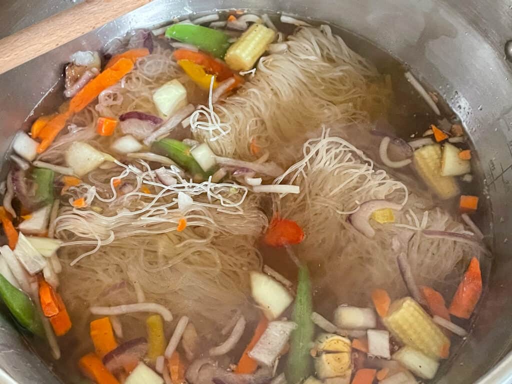 noodles and stir-fry vegetables with stock and flavourings added to soup pan.