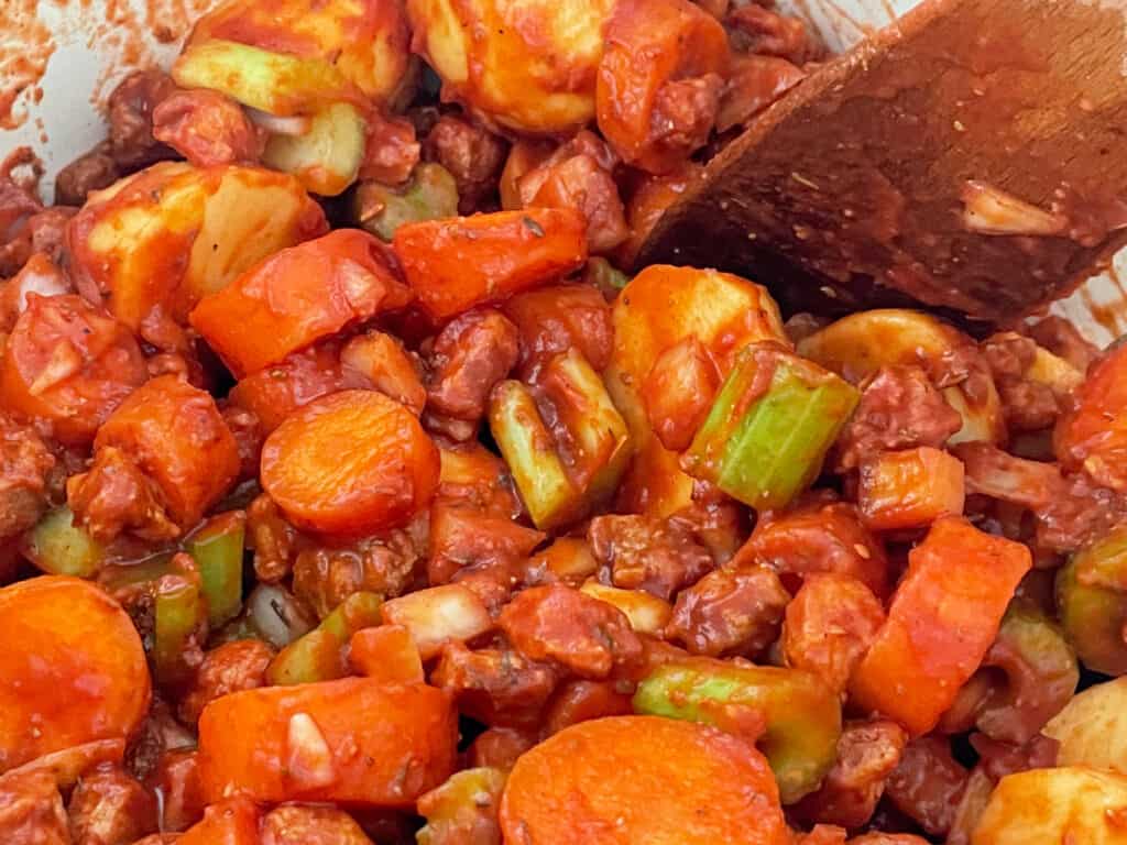 tomato puree and passata added to saucepan with beef stew veggies