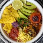 taco bean soup served in white bowl with black and white background.