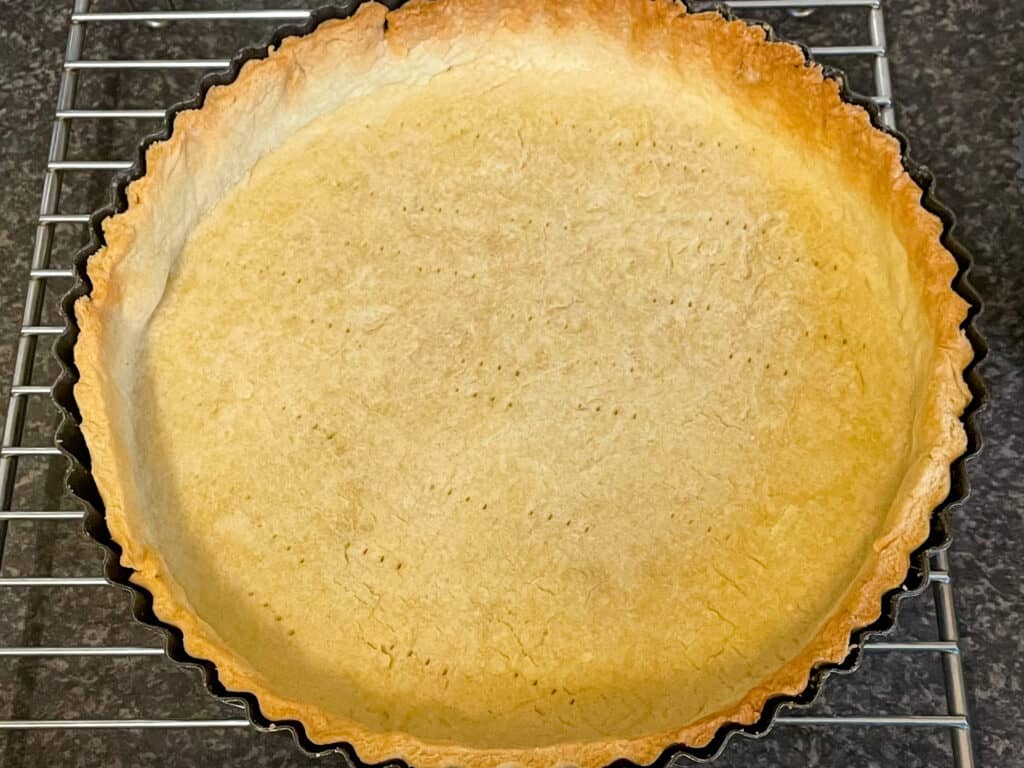 Pastry case cooked and sitting on wire rack.