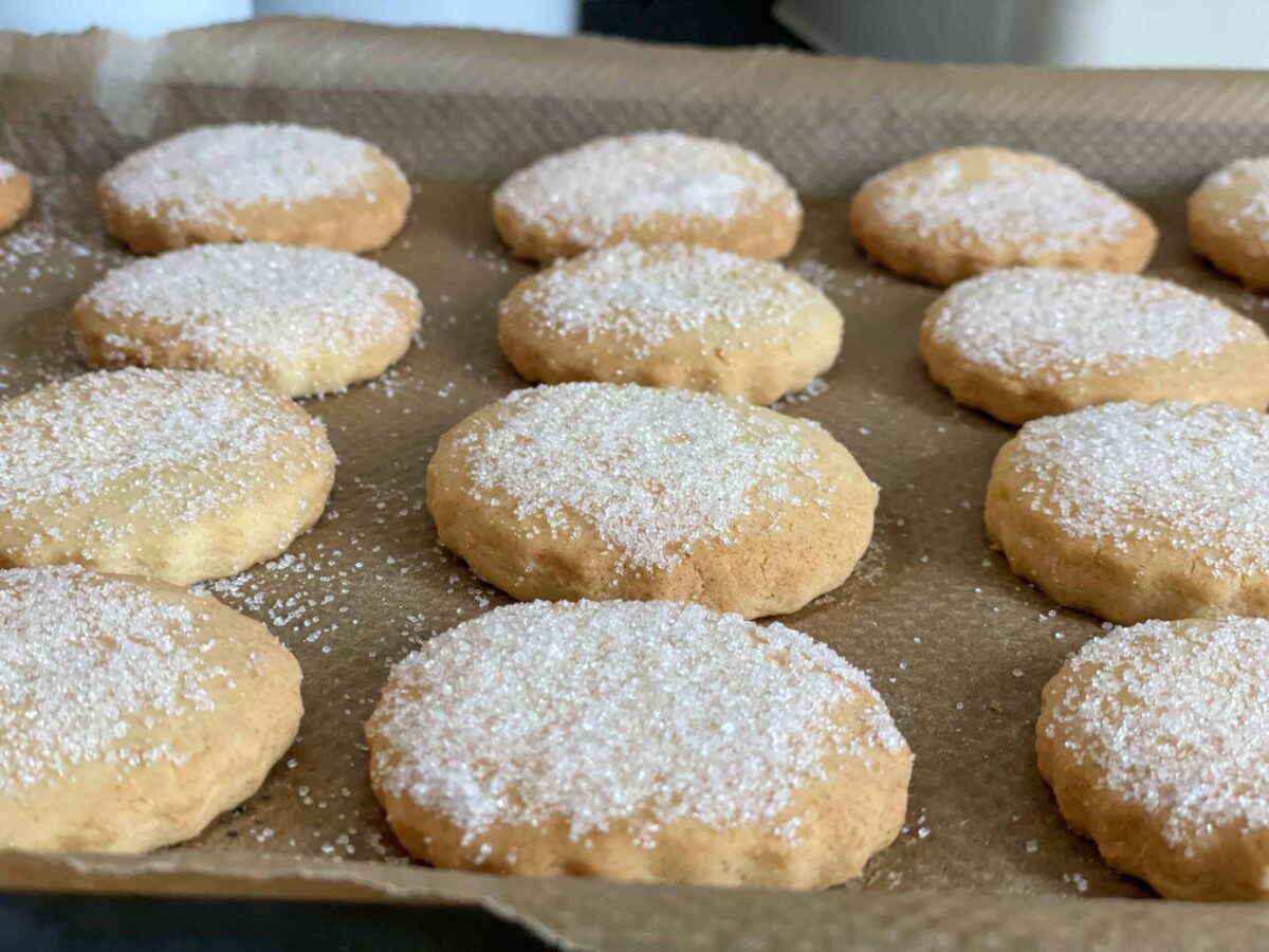 Shortbread baked and on the baking tray with sugar sprinkled over.