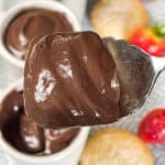 close up of chocolate pudding with chocolate pudding in background, and shortbread biscuits and strawberries in background.