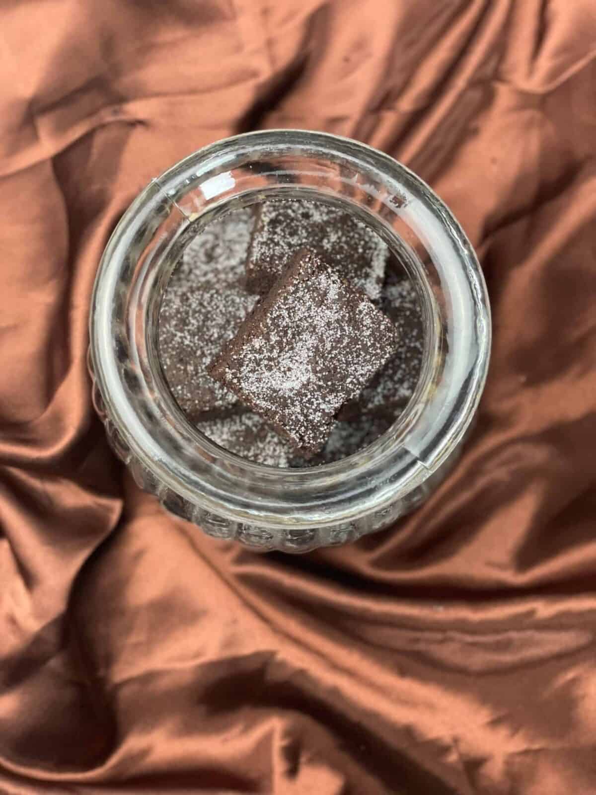 Concrete cake placed in glass jar with brown background.
