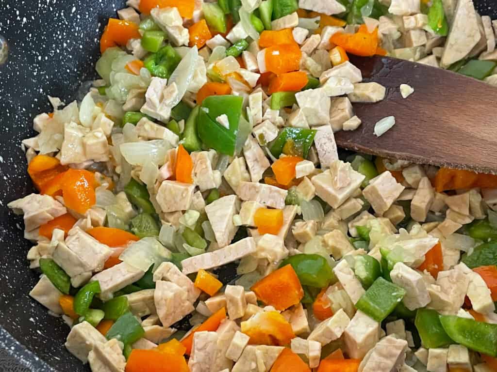 chopped peppers and tempeh added to skillet pan.