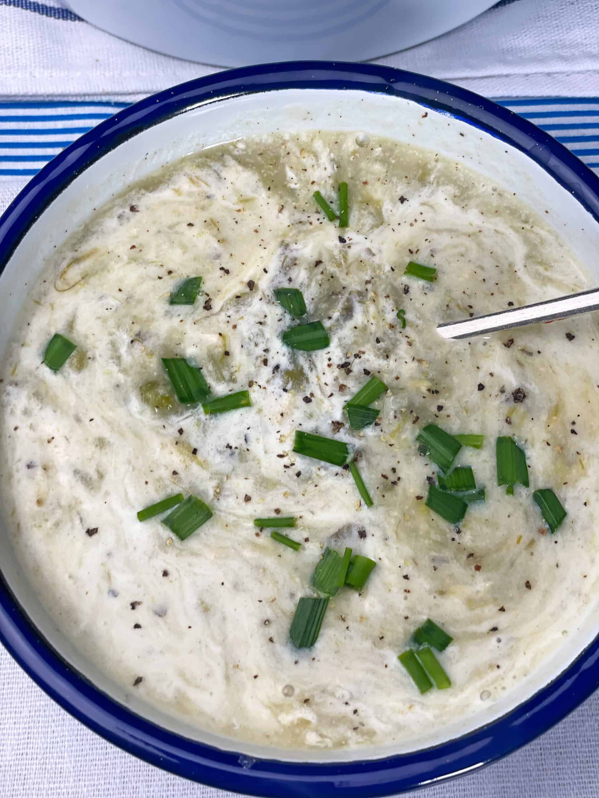 Close up bowl of chowder with cream mixed through.