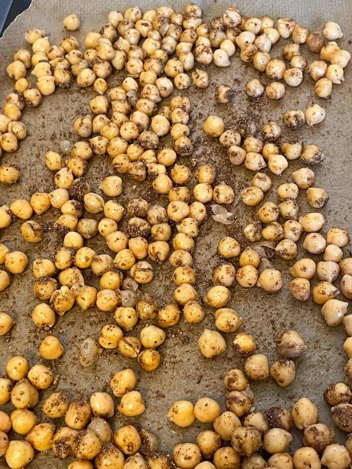 Chickpeas mixed with spices and placed on baking tray.