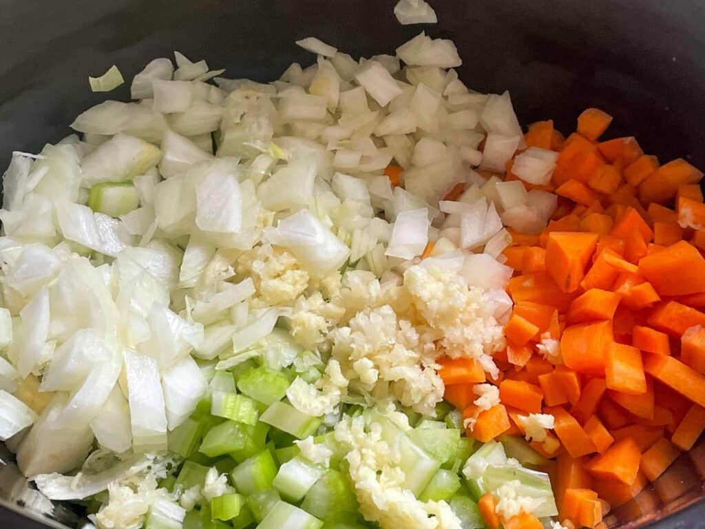 Carrots, celery, garlic and onion added to the slow cooker.