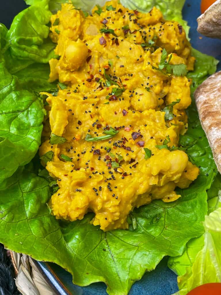 scrambled chickpeas stuffed into a large romaine lettuce leaf, pitta bread to side.