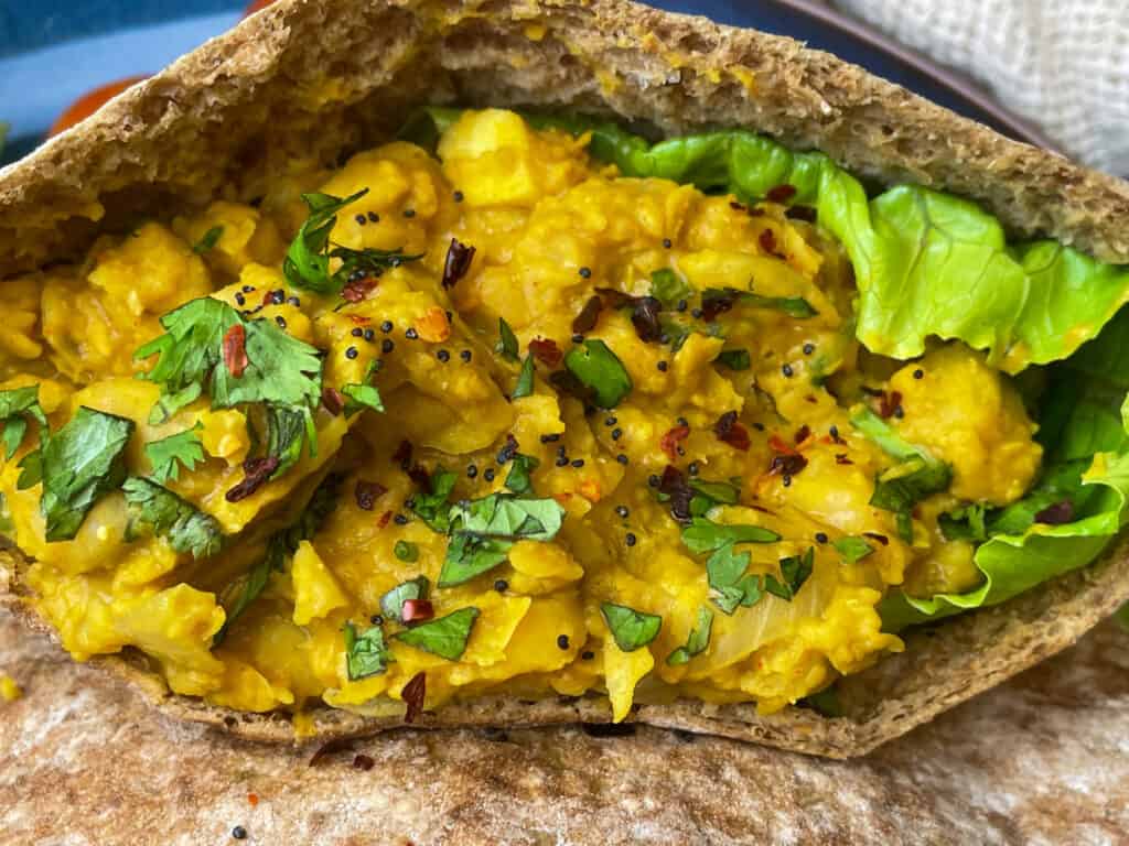 mashed chickpeas stuffed into pitta bread with coriander sprinkled over.