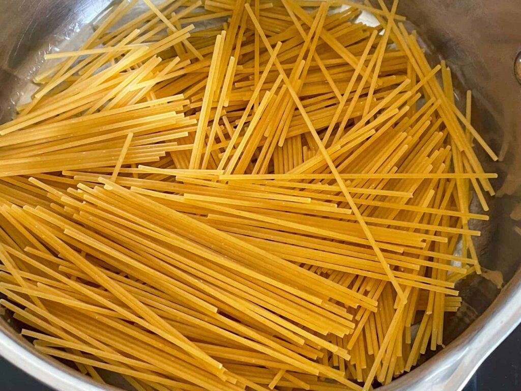 Broken spaghetti pasta in saucepan ready to cook.