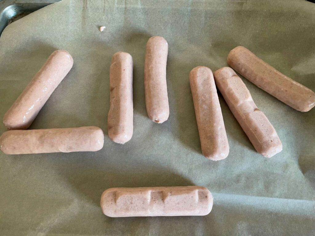 Vegan meat-free sausages on baking tray ready to bake.