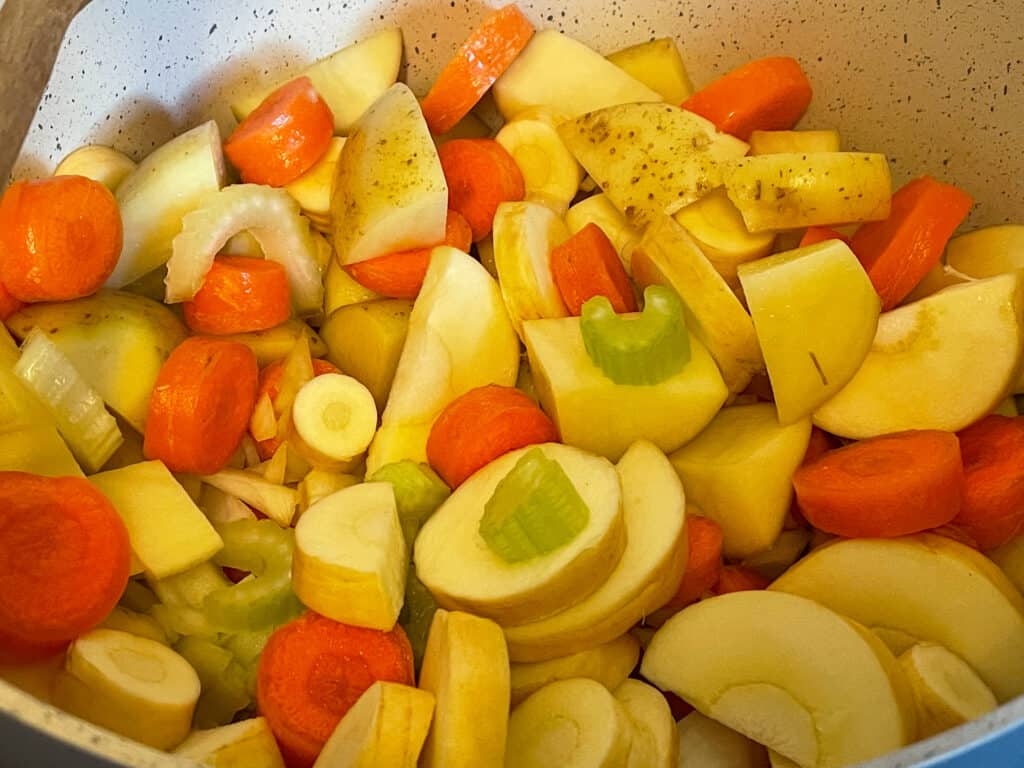 Chopped carrot, potato, celery, parsnip and onion in saucepan.