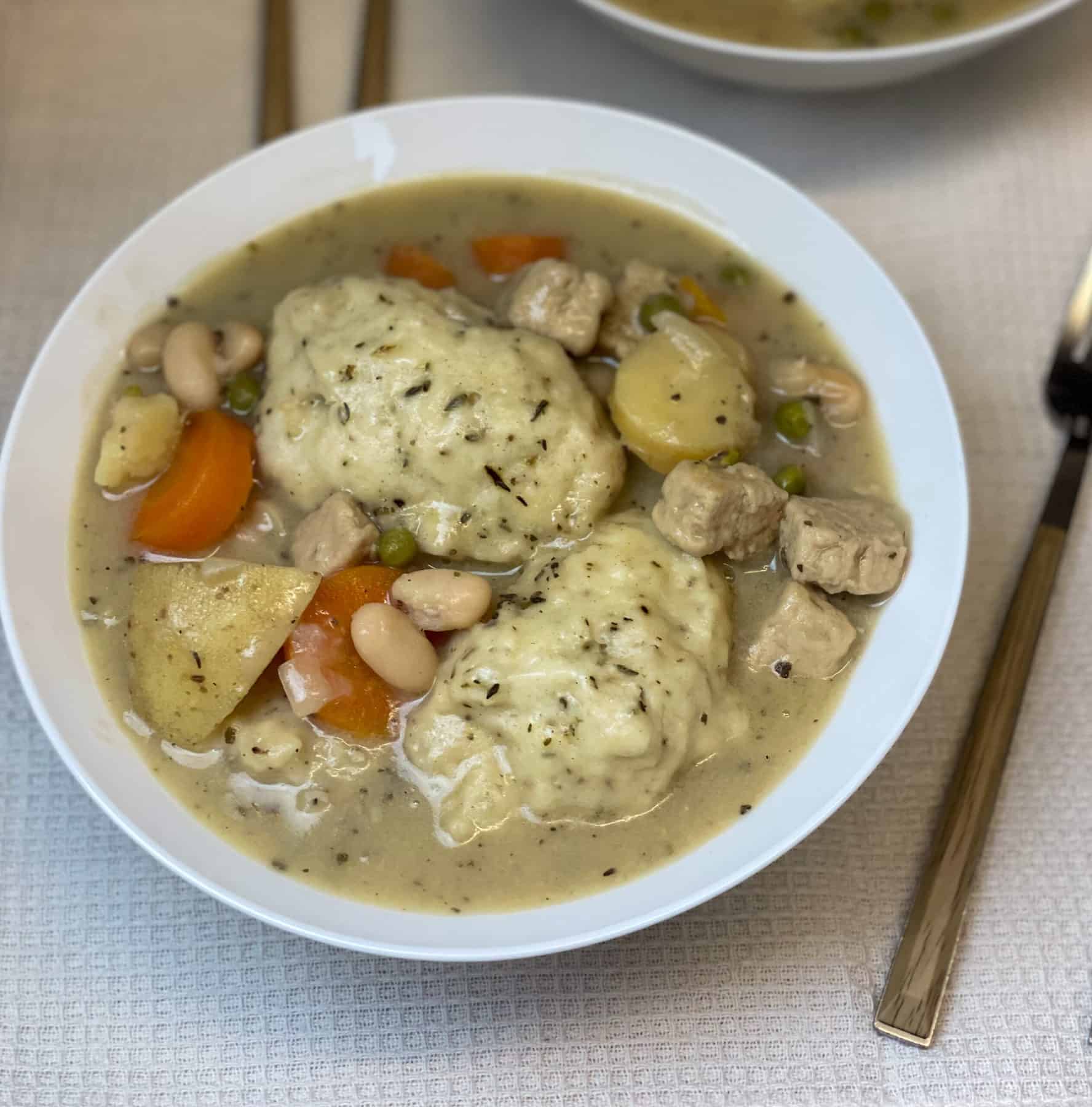 Stew served in a white bowl with a spoon to side.