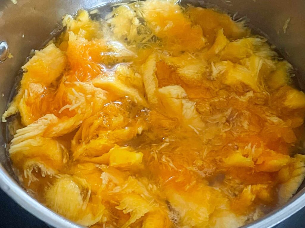 chopped pumpkin in sliver pan with water.