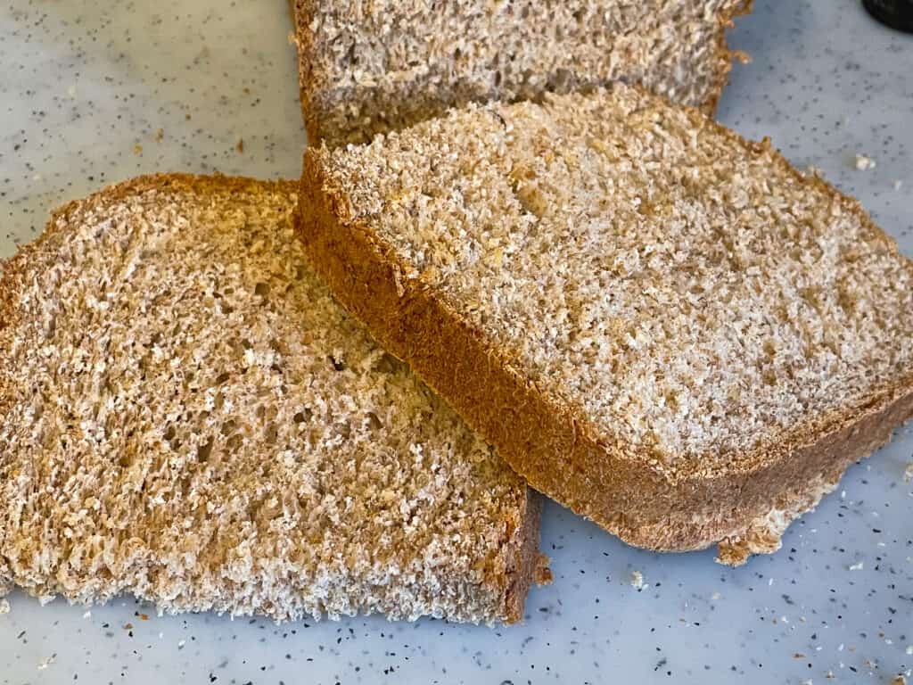 Two thick slices of wholemeal bread on chopping board.