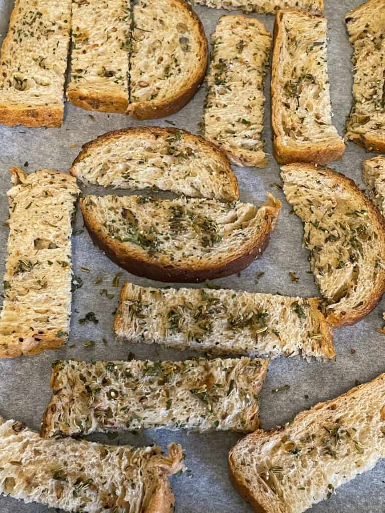 apple cider vinegar and mixed herbs mixed through bread slices and placed on baking tray.