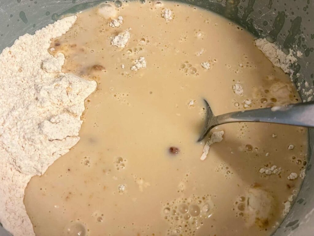 Wet ingredients poured into the dry ingredients for the vegan peanut butter bread in bowl.