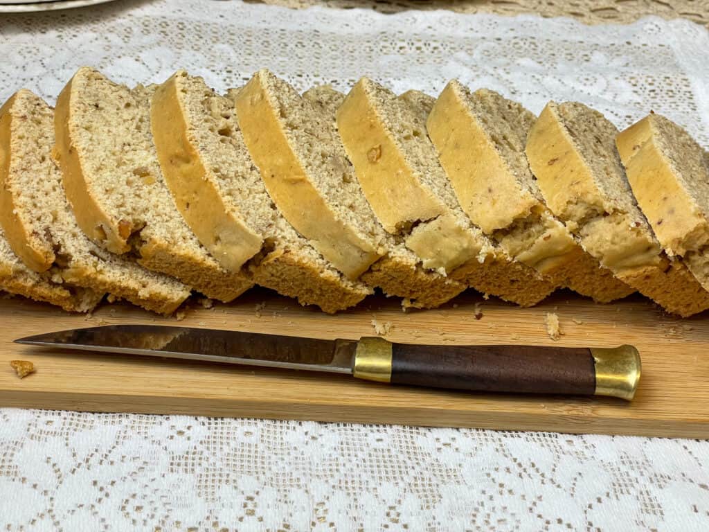 Slices of peanut bread on chopping board, side-ways view.