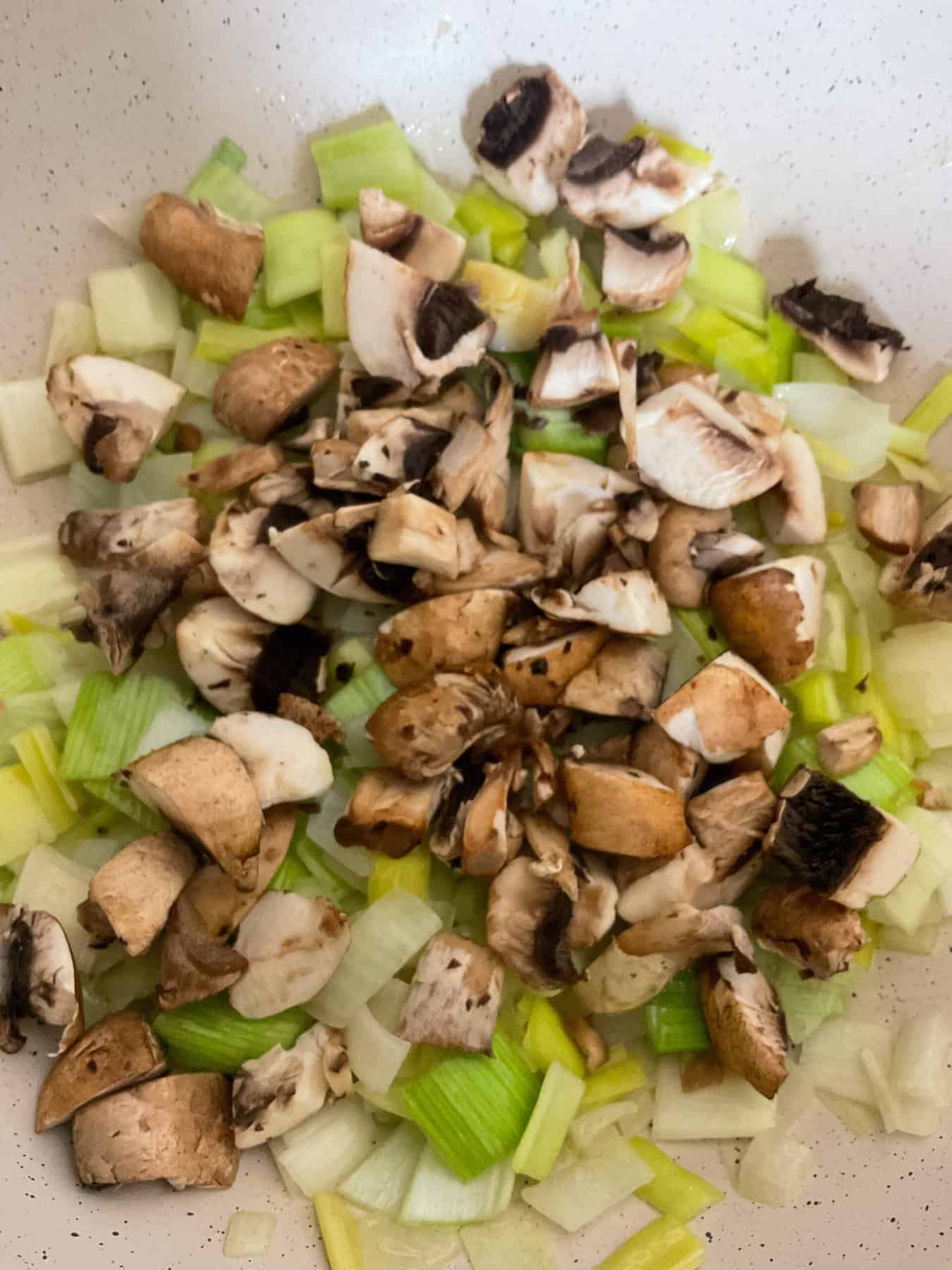 Mushrooms cooking in pan.