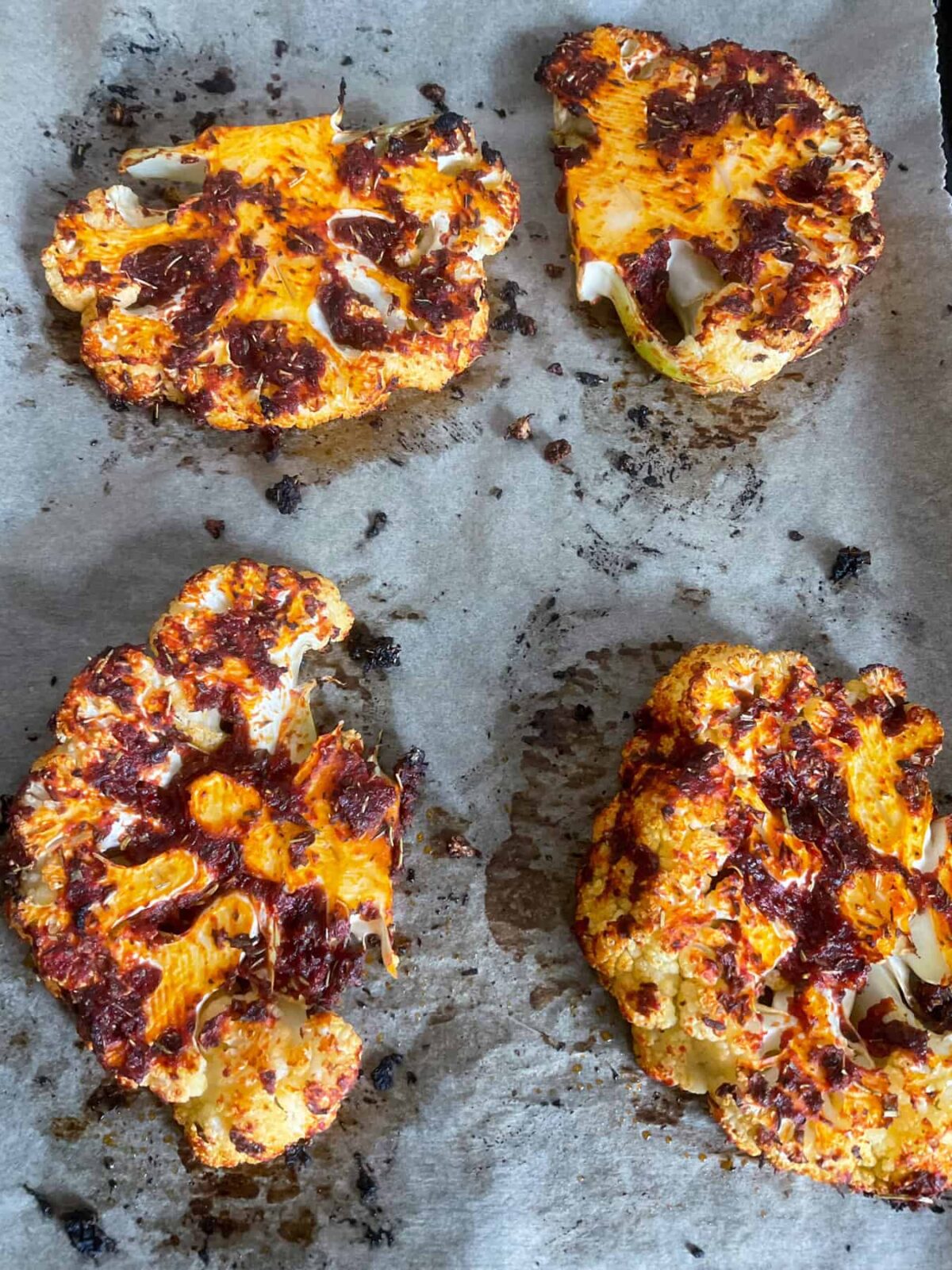 Cauliflower steaks cooked and on baking tray.