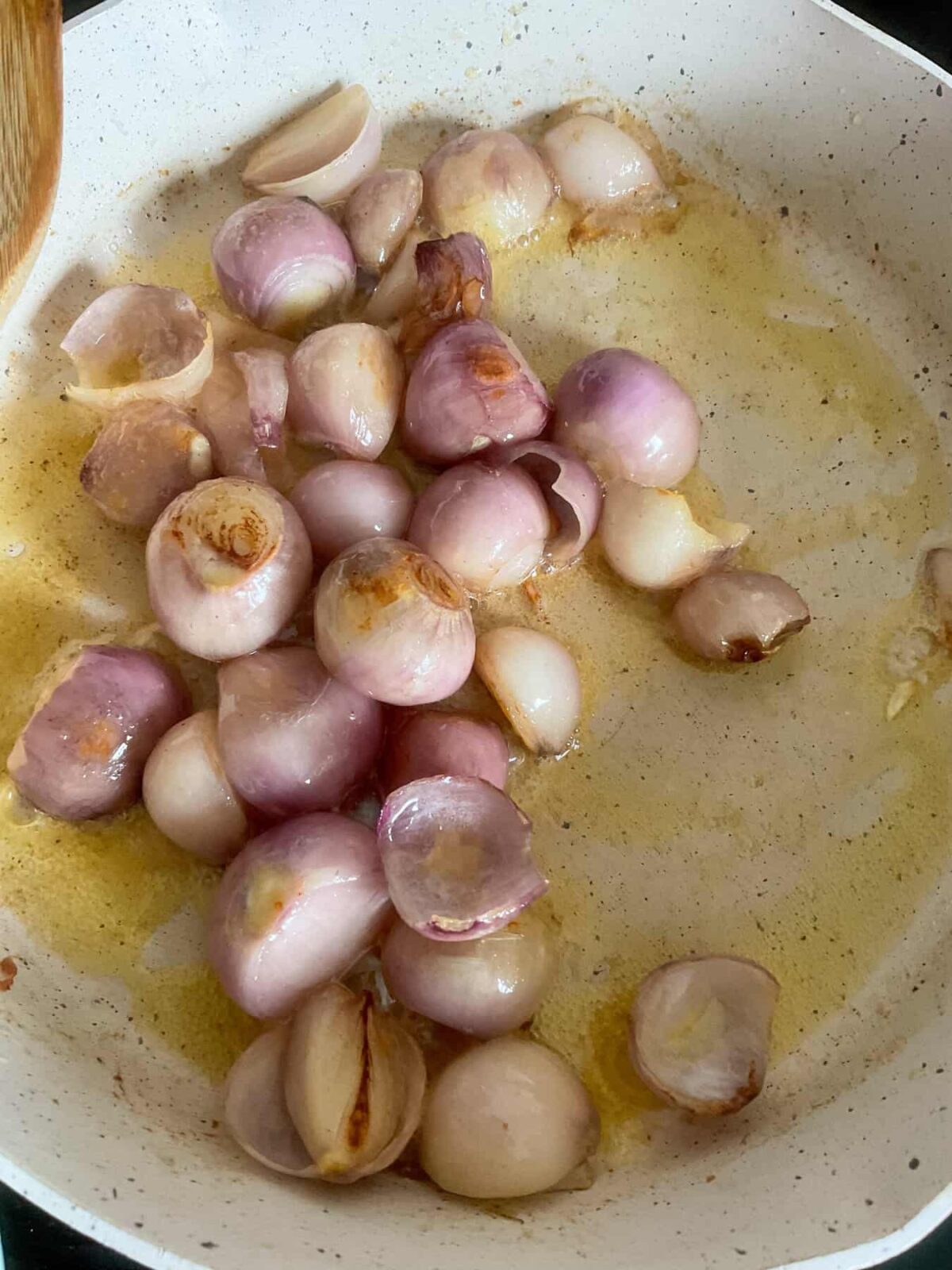 Shallots cooking in pan.