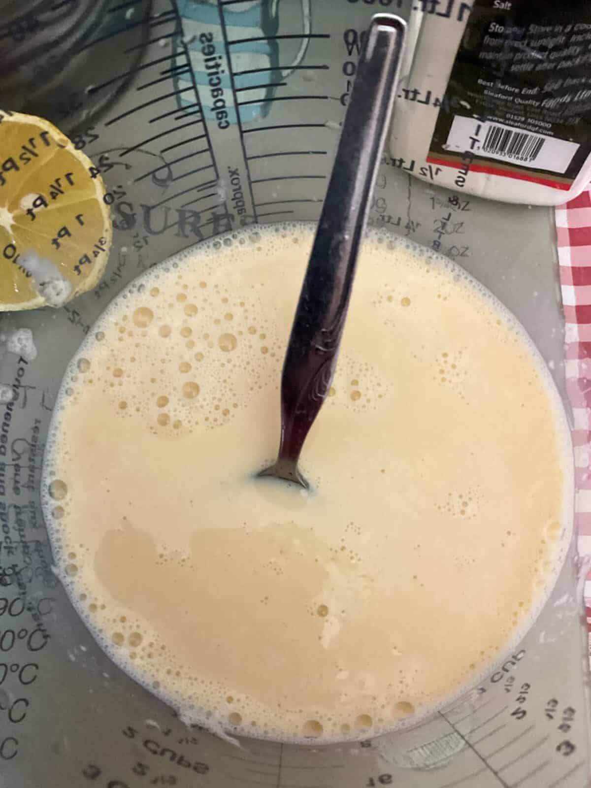 Vegan buttermilk in glass jar with silver spoon.