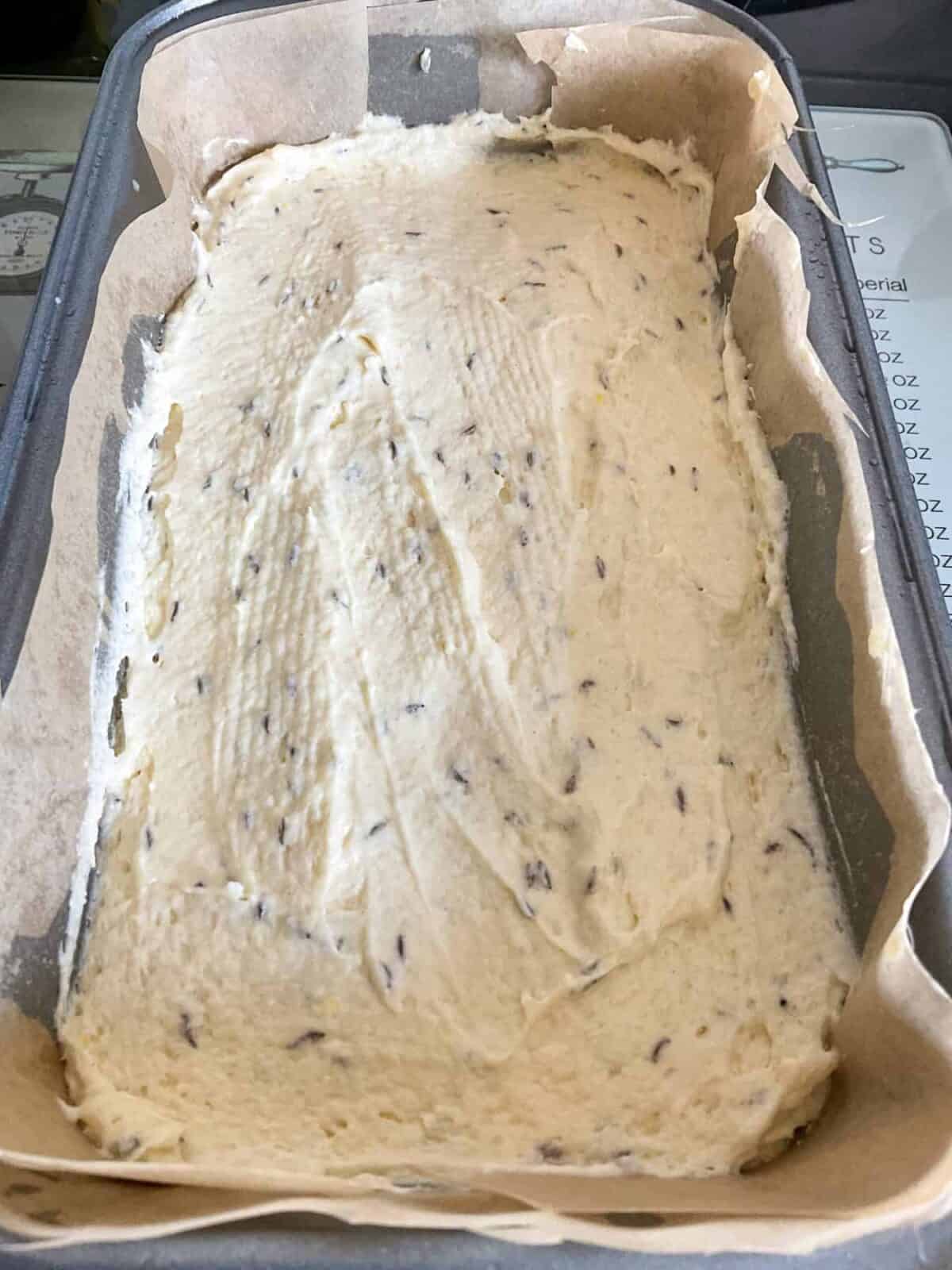 Seed cake mixture scooped into lined baking pan.
