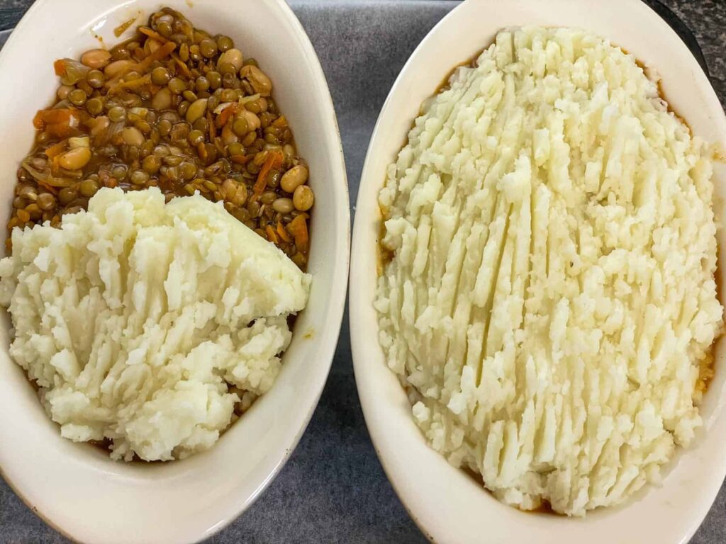 two white pie dishes filled with bean pie filling, one dish covered with mashed potato topping and the other half covered with potatoes.