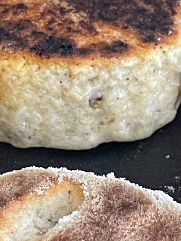 Welsh cake cooking on hotplate, risen and golden in colour.