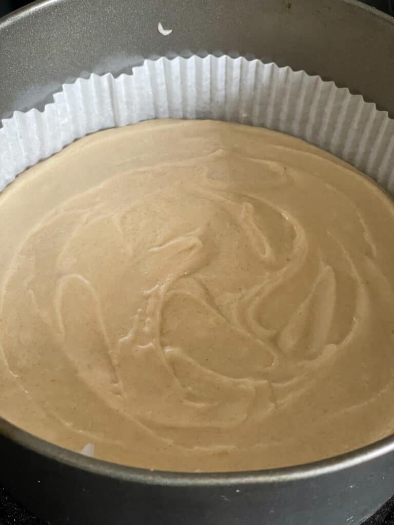 coffee cake ingredients whisked together and poured into a cake pan with paper insert.