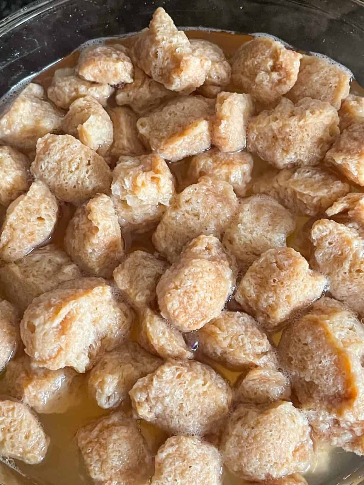 Textured vegetable protein chunks soaking in stock.