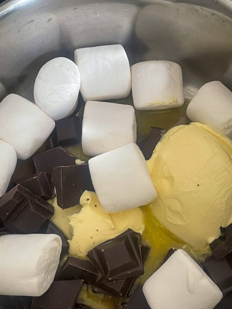 Marshmallows, margarine and chocolate in saucepan.