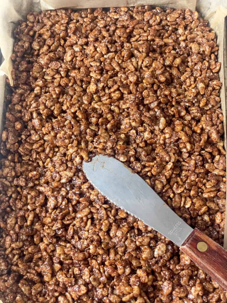 Melted chocolate mix combined with rice crispy's and pressed into a baking pan with small spatula.