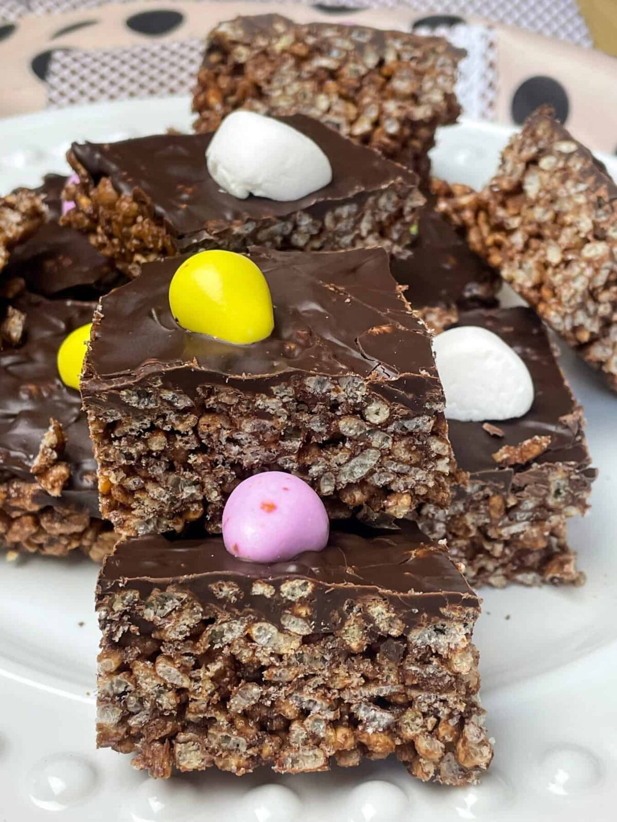 A pile of chocolate rice crispy cakes on a white plate.