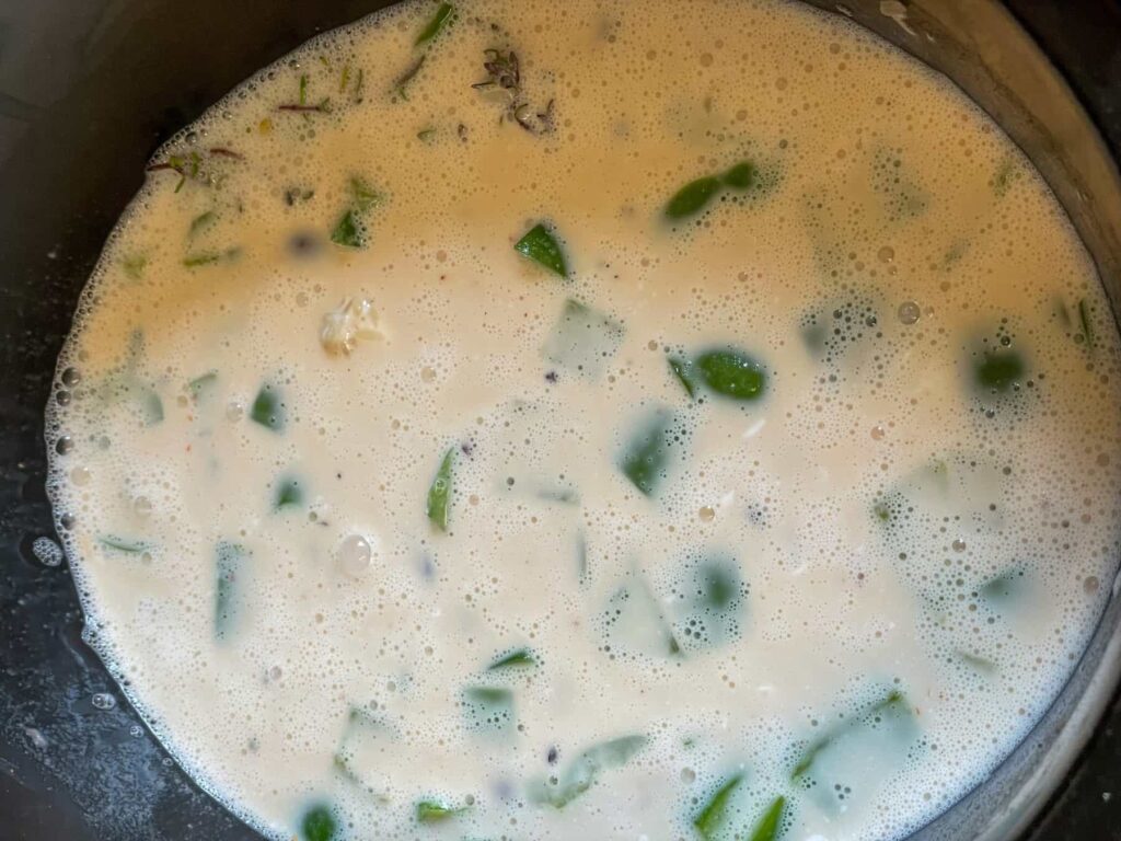 coconut milk added to rice and pea ingredients in the slow cooker.