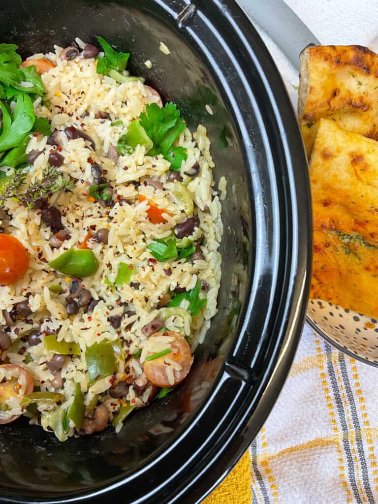 slow cooker with rice and peas and flatbreads on side, close up.