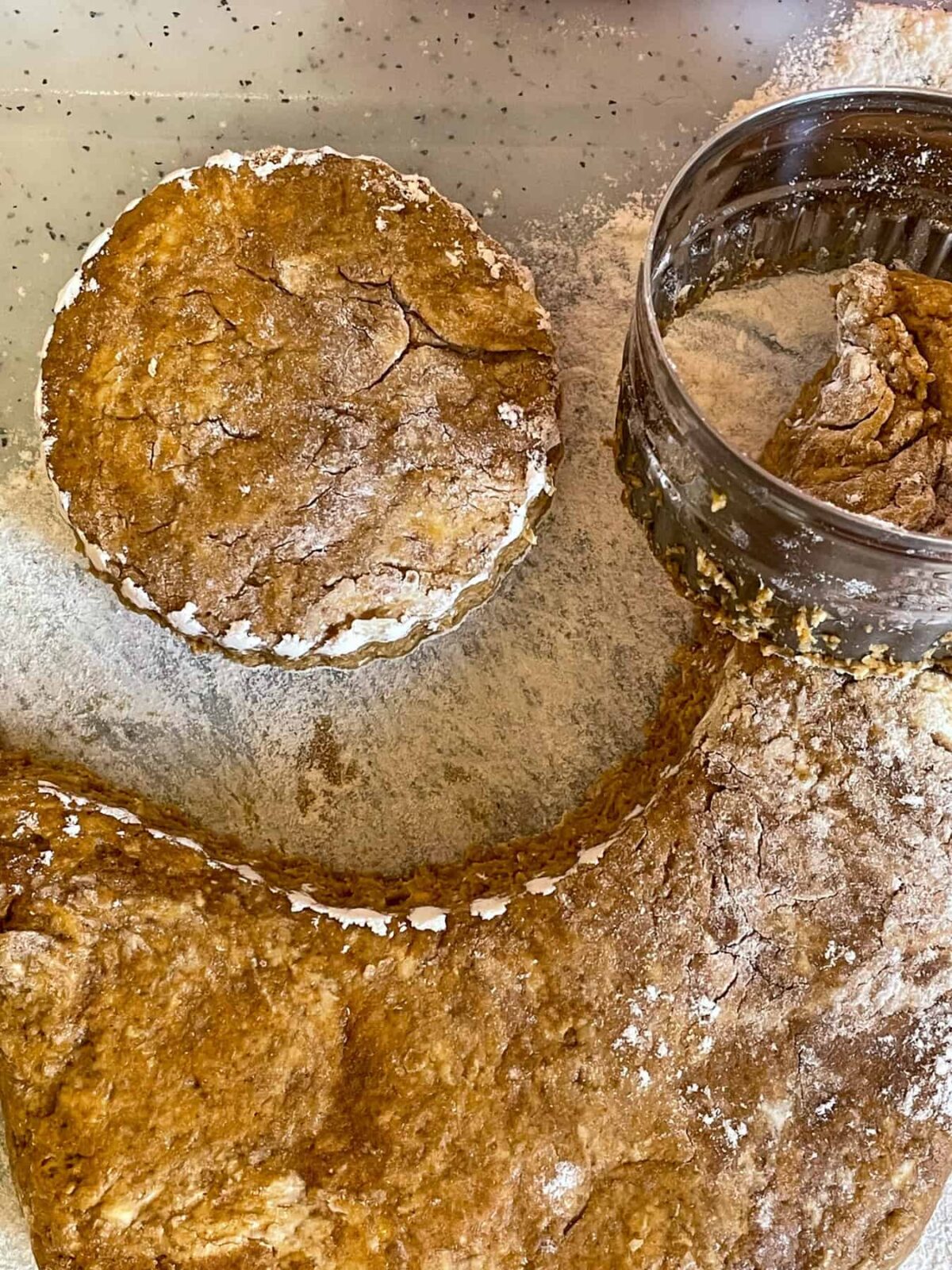 Treacle scone dough rolled out and biscuit cutter used to stamp scone out on the floured board.