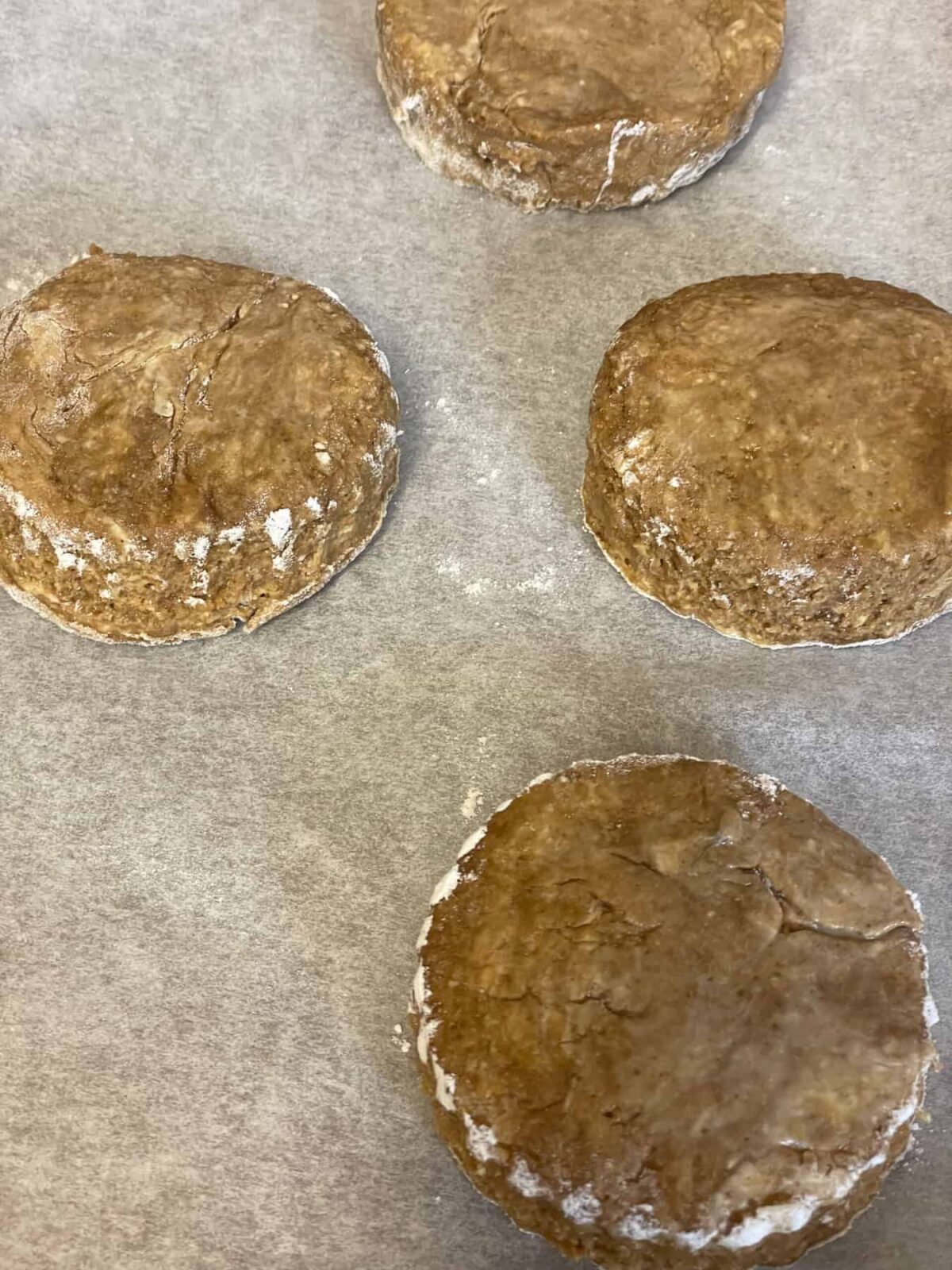 Four unbaked scones on baking tray.