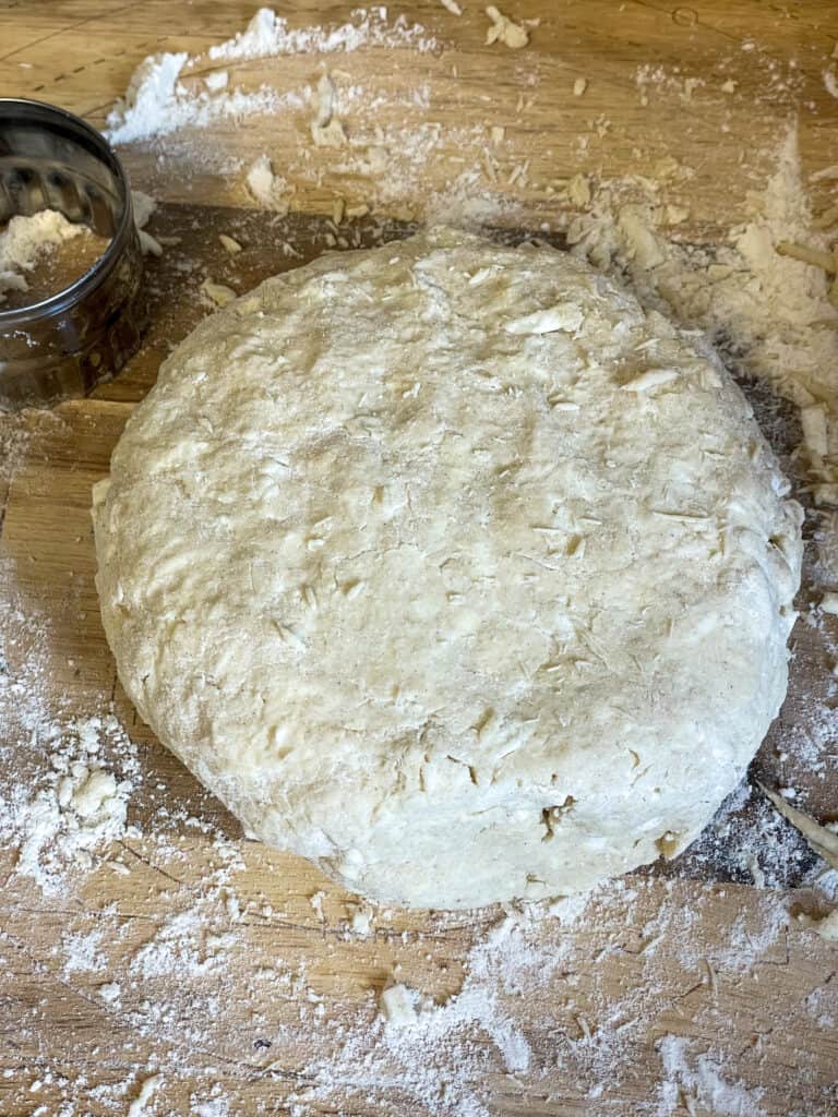 ingredients brought together into a dough ball and placed onto wooden board, cookie cutter to side.