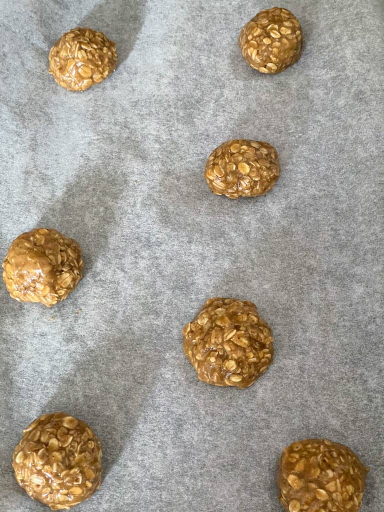 Baking tray with balls of oatmeal cookie dough.