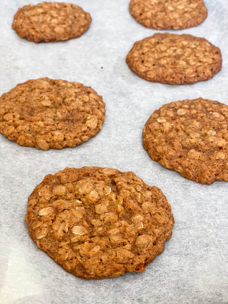 Oatmeal cookies baked and cooling on baking tray.